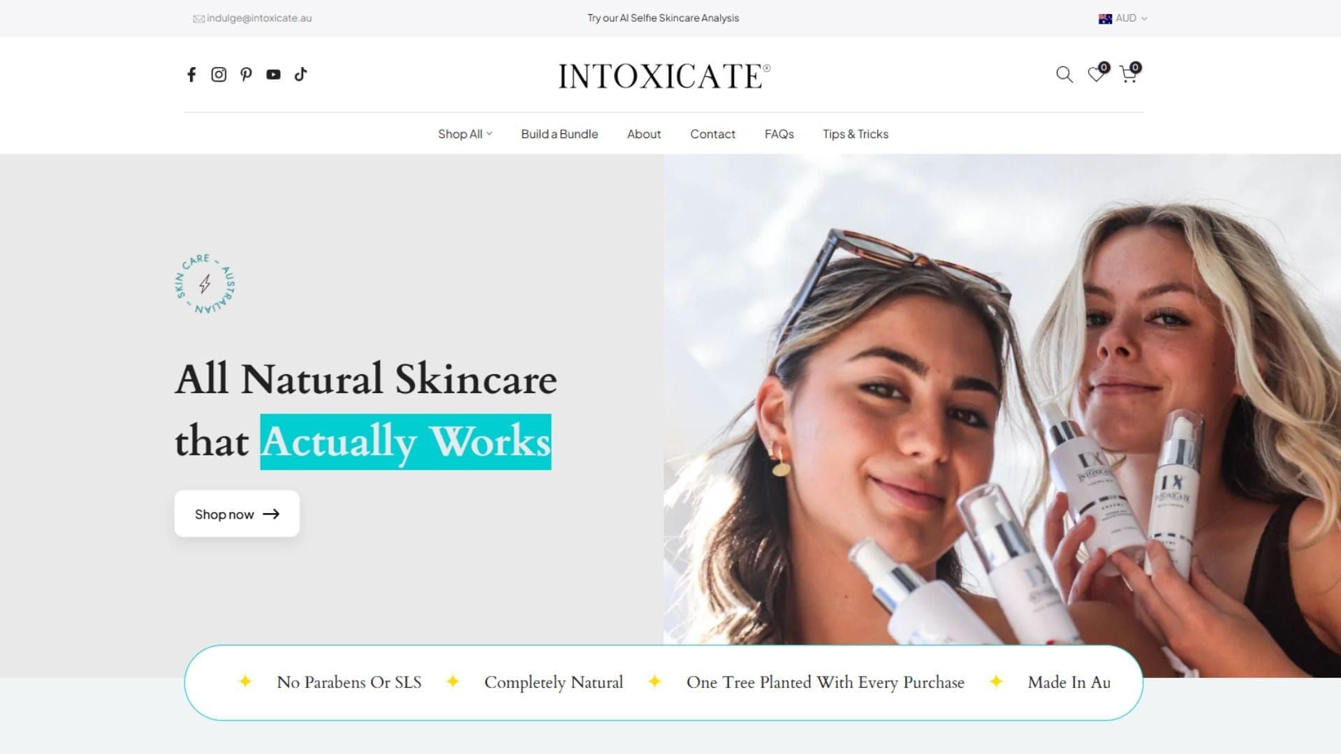 A smiling woman holding skincare bottles, promoting the brand Intoxicate's all-natural products on their website.