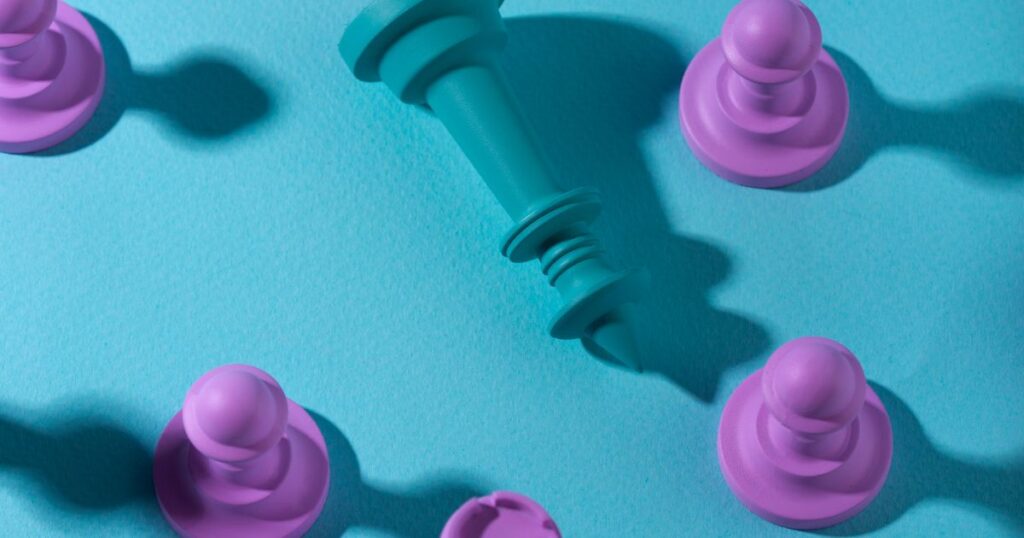 A teal chess piece stands out among purple pawns on a vibrant teal background, symbolizing strategy and competition.